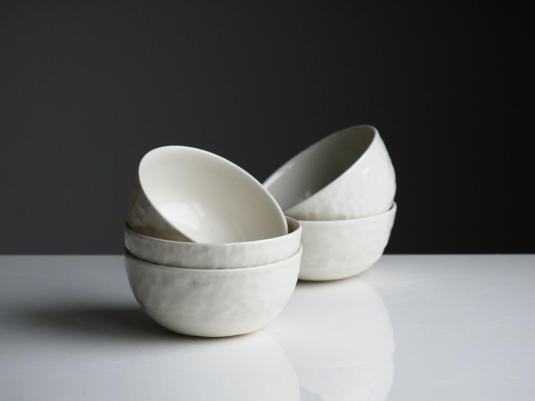 A hand-built faceted stoneware bowl in matte cream