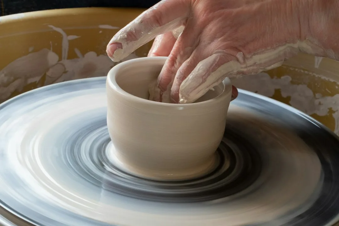 A row of pottery wheels beside a bright studio window
